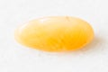 Polished yellow chalcedony rock on white marble