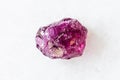 Rough Rhodolite pyrope garnet crystal on white