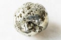 Tumbled Pyrite fool`s gold rock on white marble