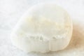 Tumbled Ulexite TV rock stone on white marble Royalty Free Stock Photo