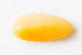 Tumbled yellow chalcedony rock on white marble