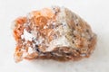 unpolished red Rock Salt (Halite) on white marble