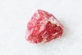 Unpolished Rhodonite crystal on white marble