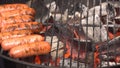 Closeup of sausage on the grill. Sausages are grilled BBQ. Grilled sausage on the flaming grill Royalty Free Stock Photo