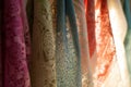 closeup of scarves with intricate lace detailing on a backlit rack