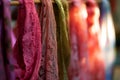 closeup of scarves with intricate lace detailing on a backlit rack