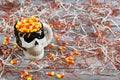 Closeup of scary Halloween skeleton skull cup filled with candy