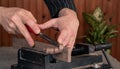 Closeup scene of hands of a male wood worker shaping wooden plank with chisel - locked in the iron vise