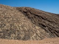 Closeup scene of rough rock mountain texture pattern view with clear blue sky background on unpaved dirt road Royalty Free Stock Photo