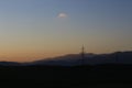 Closeup of scenic nature at sunset, powerlines, and hills on the background
