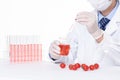 Closeup of a scientist adding toxic substances to cherry tomatoes in a laboratory