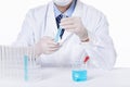 Closeup of a scientist experimenting with blue toxic substances in containers in a laboratory