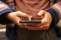 Closeup scrolling phone. Defocus female hand holding black phone. Close up of a woman using mobile smartphone Royalty Free Stock Photo