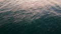 Closeup sea rippling surface reflecting morning sun. Turquoise water lapping