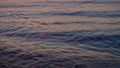 Closeup sea water surface reflecting purple sky at evening sunset dawn. Royalty Free Stock Photo