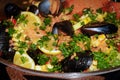 Closeup of seafood paella with lemons, mussels, and rice