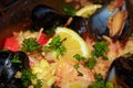 Closeup of seafood paella with lemons, mussels, and rice