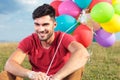 Closeup of seated casual man with balloons