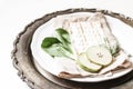 Closeup of seder dinner plate. Matzo bread, egg, apple fruit, herbs and chazeret lettuce vegetable. Vintage silver tray Royalty Free Stock Photo