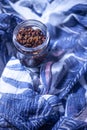 Healthy crunchy multi-seed topping in a glass jar sitting on a beautiful feminine scarf
