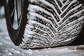 Closeup selective focus on snow packed in an all-weather tire tread.