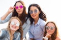 A close-up selfie of the four beautiful bridesmaids in colorful sunglasses on the background of the sky Royalty Free Stock Photo