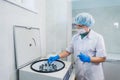 Closeup of a senior female chemist setting up some sample blood tubes inside a centrifuge for some test in a lab.