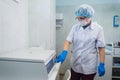 Closeup of a senior female chemist setting up some sample blood tubes inside a centrifuge for some test in a lab.