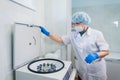 Closeup of a senior female chemist setting up some sample blood tubes inside a centrifuge for some test in a lab.