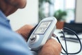 Closeup of senior man measuring blood pressure with digital sphygmomanometer, Blood pressure monitor in the medical office. The