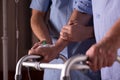 Senior man`s hands holding walker, supporting male nurse at his site Royalty Free Stock Photo