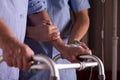 Senior man`s hands holding walker, supporting male nurse at his site Royalty Free Stock Photo