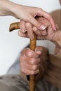 Closeup of senior mans hands and young girl caregiver holding hands on walking stick Royalty Free Stock Photo