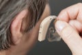 Closeup senior woman using hearing aid