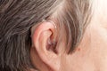 Closeup senior woman using hearing aid