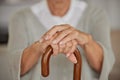 Closeup of a seniors hands, disabled woman holding a cane in a nursing home. An elderly lady needing a walking aid or