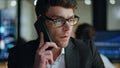 Closeup serious businessman call client in dark office. Thoughtful man manager