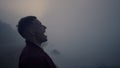 Serious man walking on sea shore in morning fog. Angry guy screaming on beach Royalty Free Stock Photo