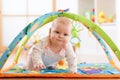 Closeup of seven months baby girl crawling on colorful playmat