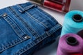 closeup of sewing thread spool bobbin on white table on blue jeans background Royalty Free Stock Photo