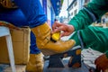 Closeup of shoeshiner working on yellow boots in