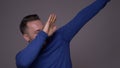 Closeup shoot of young handsome caucasian man dabbing with confidence in front of the camera with background isolated on