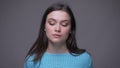 Closeup shoot of young pretty brunette female looking at camera with thoughtfulness with background isolated on gray