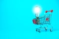 Closeup shopping cart and light bulb for e-commerce or shopping concept on white background