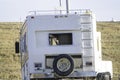 Closeup shot of an abandoned white recreational vehicle in the field Royalty Free Stock Photo