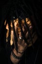 Closeup shot of an African-American male with dreadlocks covering his face with cloth in grief