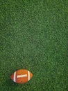 Closeup shot of an american football ball in a green field with natural light Royalty Free Stock Photo