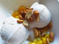 Closeup shot of an appetizing coconut ice cream with nuts and corn toppings