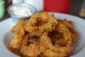 Closeup shot of an appetizing onion ring crisps bowl with a white dipping sauce