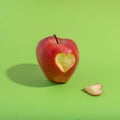 Closeup shot of an apple with heart cut shaped isolated on green background Royalty Free Stock Photo